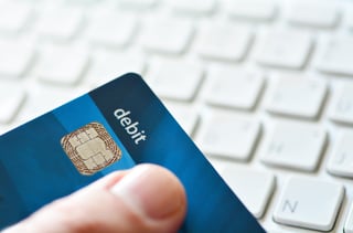 Person using a debit card for online payment