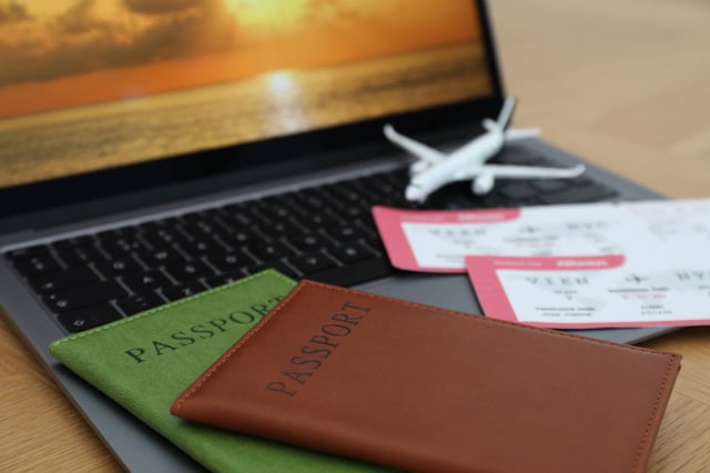 Passports Flight Tickets Plane Model And Laptop On Wooden Table Closeup